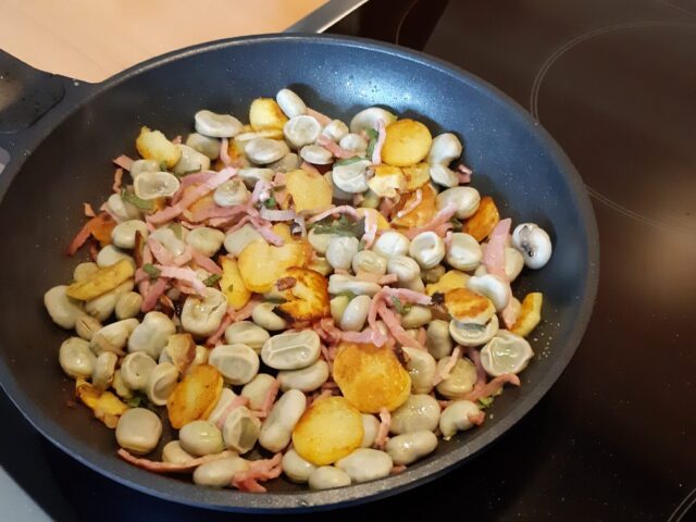 Tuinbonenpannetje met salie, gebakken aardappelschijfjes en hamreepjes