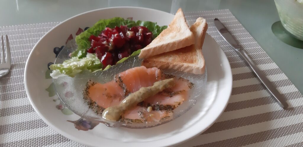 Voorgerecht met graved lachs, honing-mosterd-dillesaus. gegarneerd met bietjessalade
