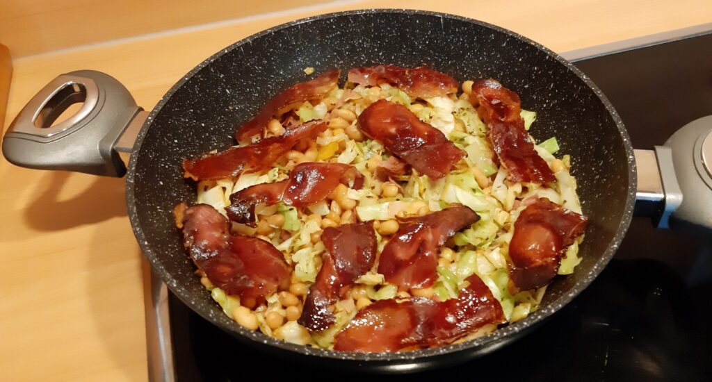 Witte bonen in tomatensaus met gebakken spitskool en spek