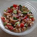 Witte bonensalade met komkommer, tomaat, kappertjes en rode ui