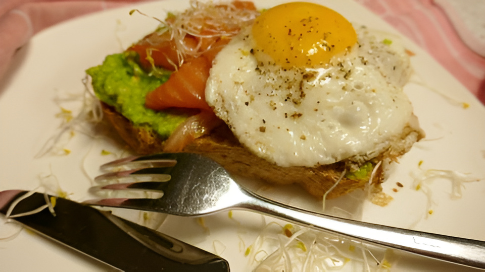 Bruine bol met avocado, zalm en een eitje