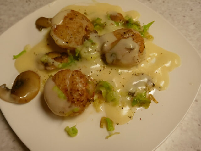 Coquilles in Champagneroomsaus met gefrituurde prei