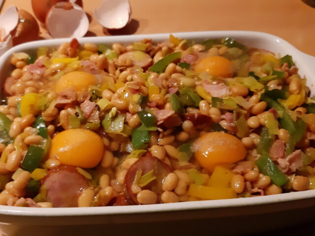 Engelse witte bonenschotel met rookworst, eieren, prei en paprika