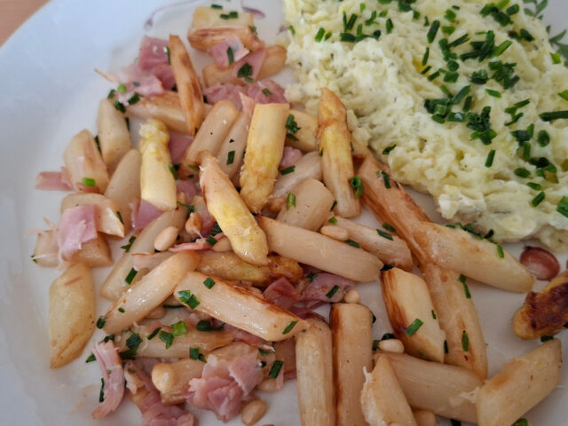 Gekarameliseerde witte asperges met ham, kaas en pijnboompitten