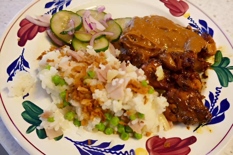 Gekleurde rijst met ketjapkip en pindasaus.