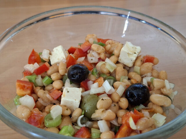 Griekse witte bonensalade met feta, paprika, olijven en lente-uitjes