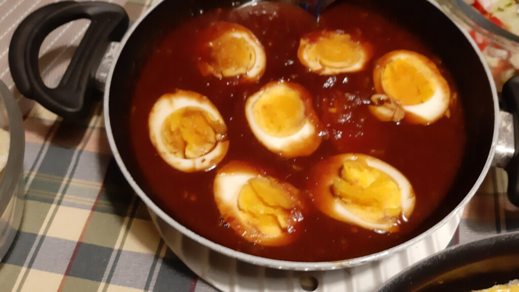 Halve eieren in een pittige tomaten-chilisaus