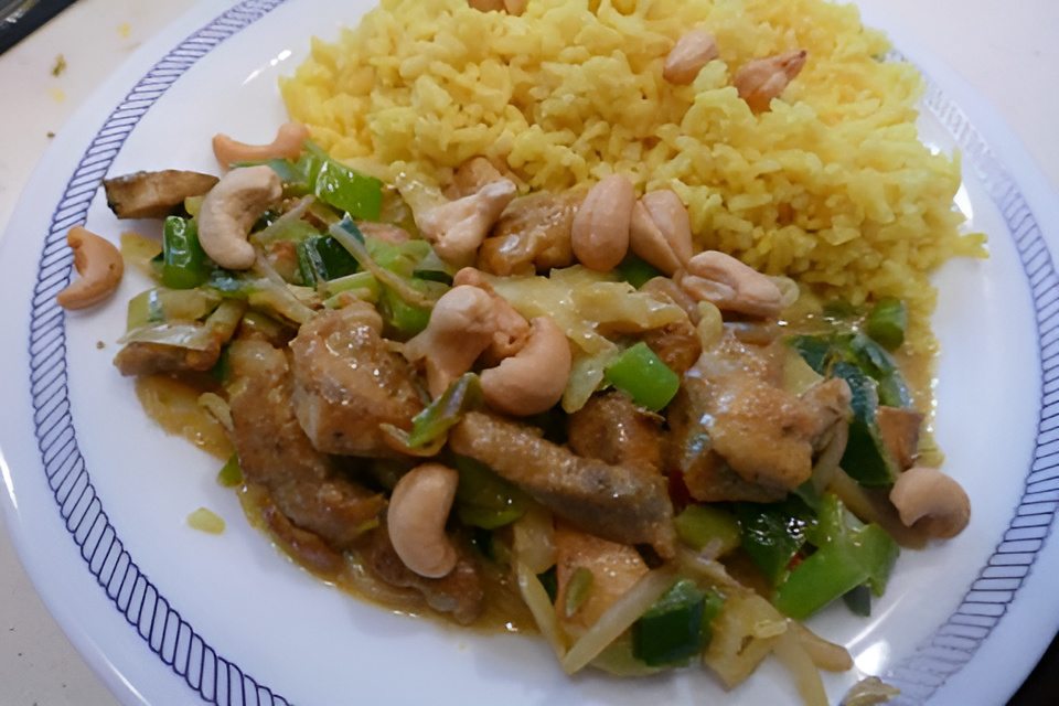 Indiase kip wokschotel met gele rijst en knapperige cashewnootjes...