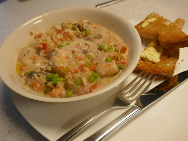 Kleurrijk, romig vispannetje met witte tonijn, zalm en gamba’s