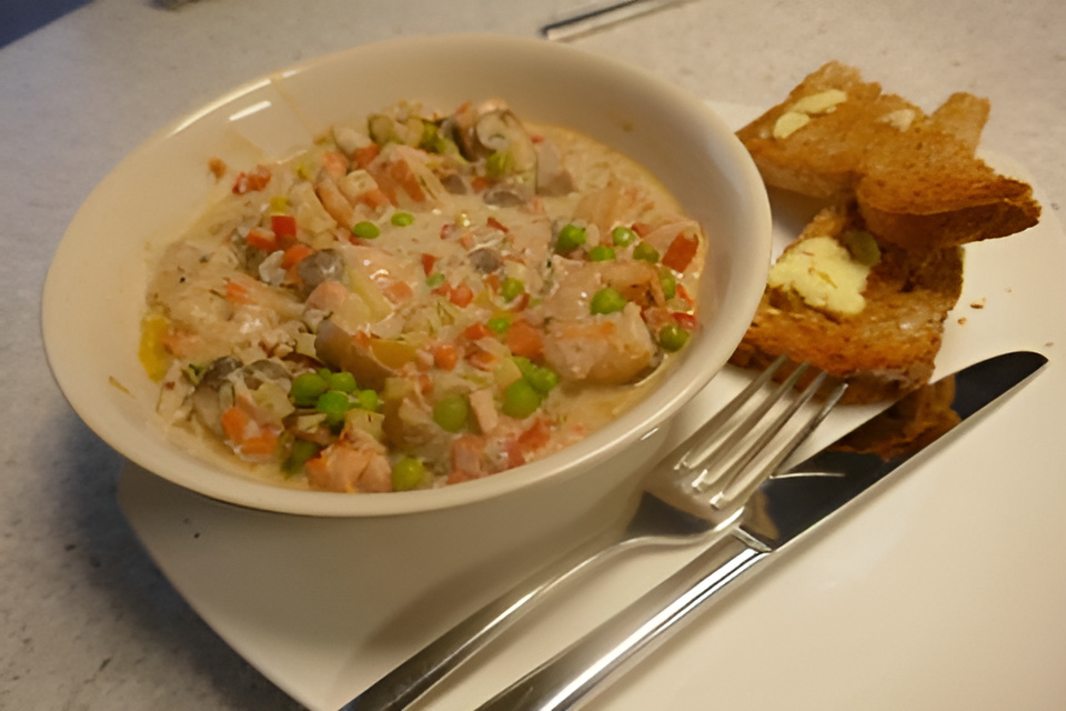 Kleurrijk, romig vispannetje met witte tonijn, zalm en gamba's