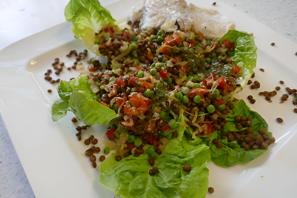 Lauwwarme linzensalade met tuinerwtjes, paprika en kabeljauw .