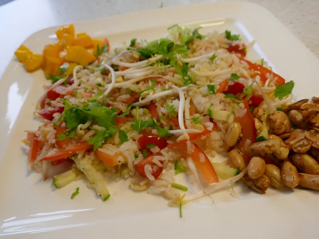 Lauwwarme rijstsalade met gebakken pittige pinda’s en mango
