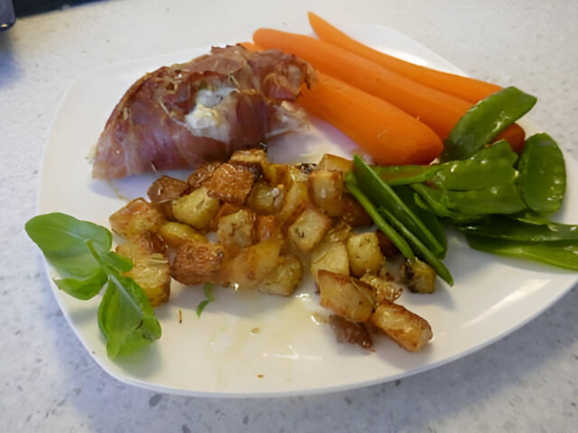 Met ricotta gevuld kipfileetje gerold in Parmaham van de bakplaat.