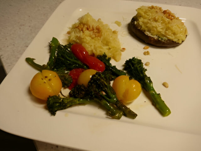 Met risotto gevulde portobello, geroosterde bimi en cherrytomaatjes .