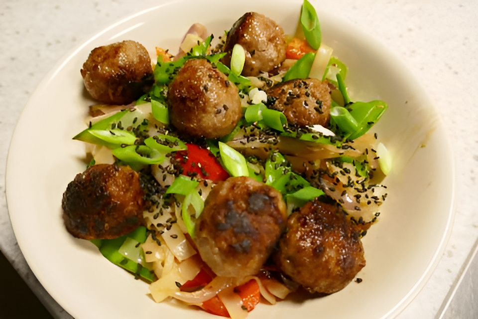Oosterse balletjes met rijstnoedels en peultjes uit de wok....