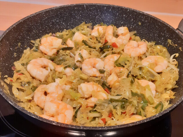 Aziatisch gekruide spitskool met prei, paprika en grote garnalen.