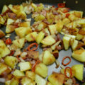 Pittige aardappeltjes met rode peper , spekjes , knoflook en sjalot.