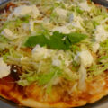 Pittige Gehaktpizza met ijsbergsla en lichte frisse knoflooksaus.