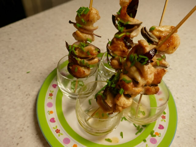 Spiesjes van kipfilet met rode ui en bieslook uit een glaasje…..