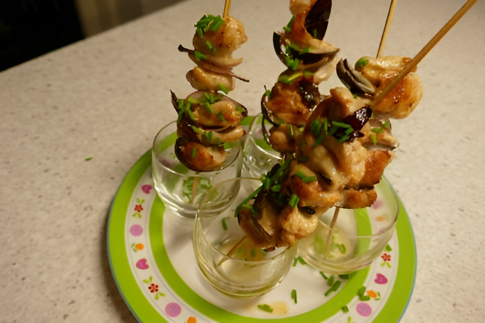 Spiesjes van kipfilet met rode ui en bieslook uit een glaasje.....