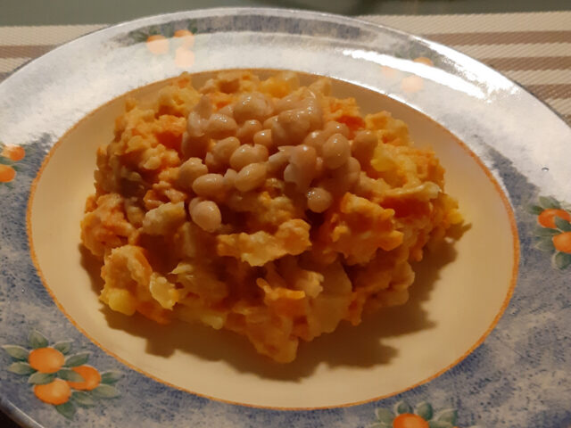 Vegetarische hutspot van winterpeen, aardappelen, gebakken uien en witte bonen