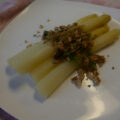 Witte asperges met gemengde broodnotenkruimels.