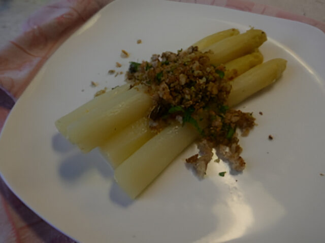 Witte asperges met gemengde broodnotenkruimels.