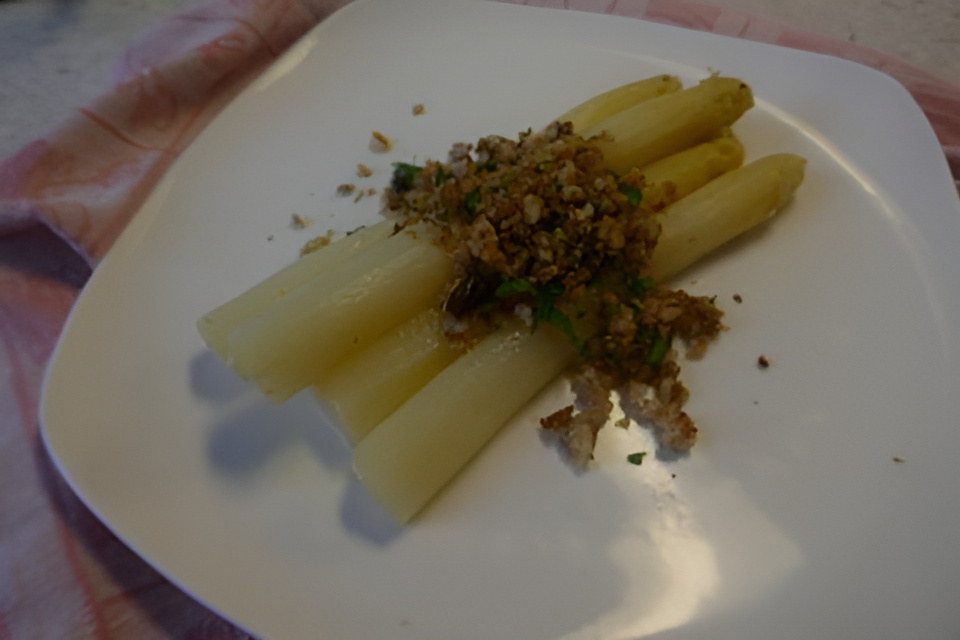 Witte asperges met gemengde broodnotenkruimels.