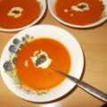 Pittig gekruide wortel-tomatensoep met sherry, basilicumpesto en room