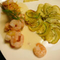 Zalm en garnalen in wittewijnsaus met een aardappel-courgette-roosje.