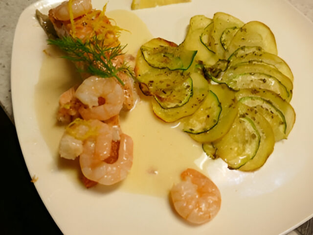 Zalm en garnalen in wittewijnsaus met een aardappel-courgette-roosje.